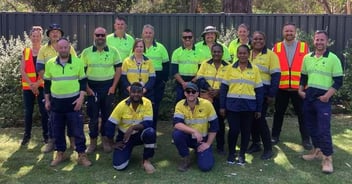 Group photo of Goulburn Valley Water and Solomon Water teams outdoors, wearing high-visibility clothing.